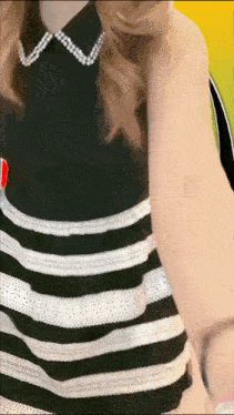 a woman wearing a black and white striped dress with pearls on the collar