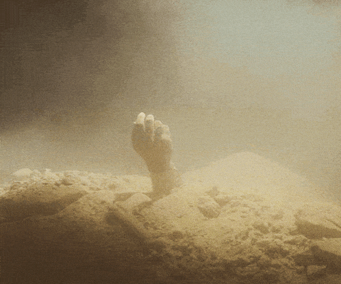 a hand sticking out of the ground in a dark room