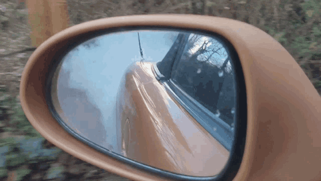 a close up of a car rear view mirror with a reflection of a car