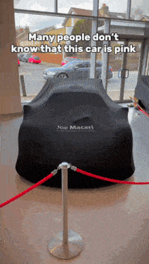 a joe macari car is covered in black cloth