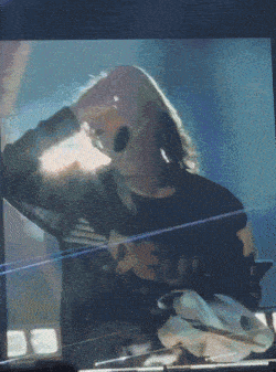 a blurry picture of a person wearing sunglasses and a shirt that says nirvana