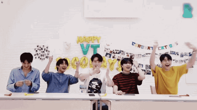 a group of young men are sitting at a table with balloons that say happy vt and congratulations