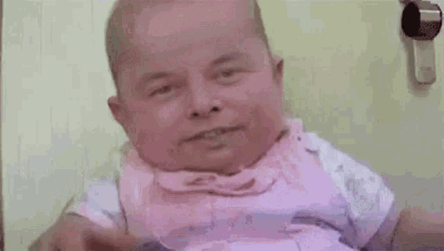 a baby is sitting in a high chair with a straw in his mouth .