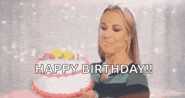 a woman is blowing out candles on a birthday cake .