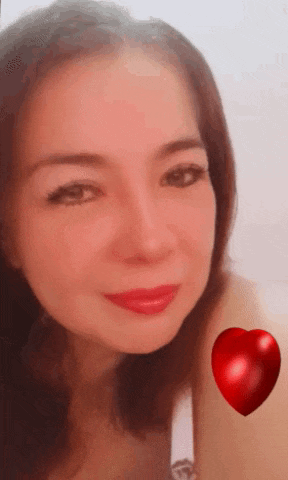a woman with red lipstick and a red heart behind her .