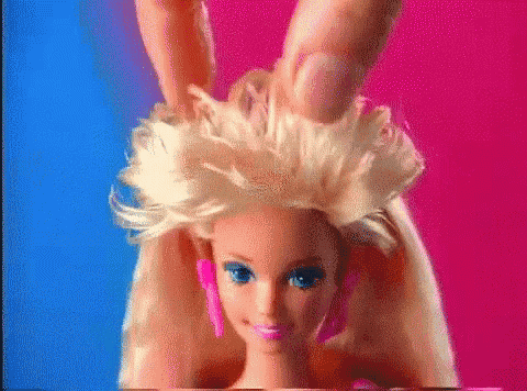 a close up of a barbie doll being held by a person