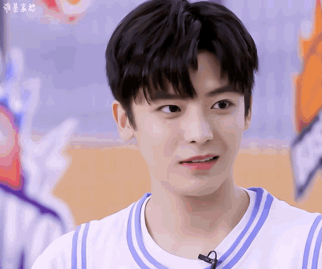 a close up of a young man wearing a white shirt with a blue stripe