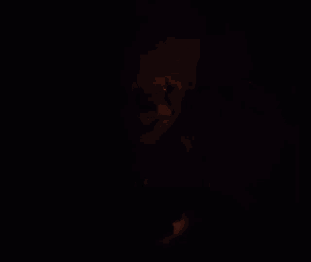 a close up of a scary clown in the dark .
