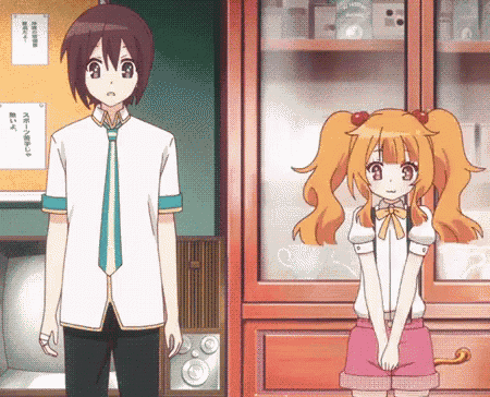 a boy and a girl are standing next to each other in front of a bulletin board with chinese writing on it