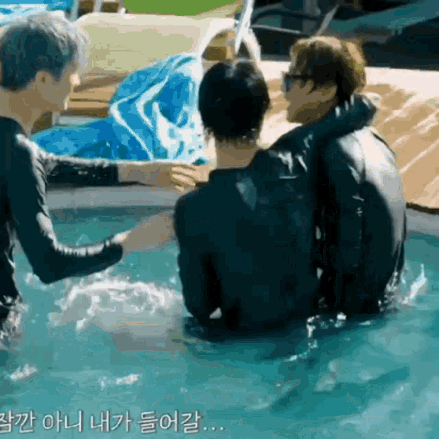 a group of men are sitting in a swimming pool talking to each other .