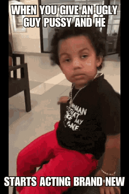 a young boy wearing a black shirt that says woman on the back