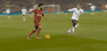 a soccer player in a red jersey is kicking a ball on the field