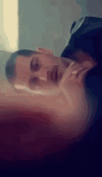 a blurry picture of a man laying on a bed with his eyes closed