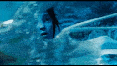 a woman is swimming in a pool and looking out of the water