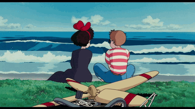 a boy and a girl are sitting on a plane looking out over the ocean