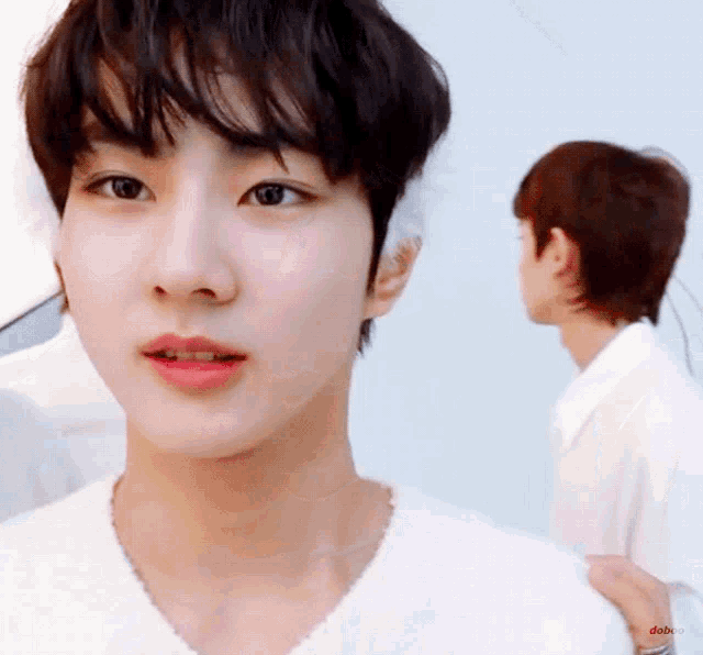 a close up of a person 's face with a man standing behind him