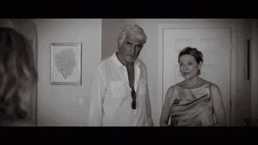 a man and a woman are standing next to each other in a hallway in a black and white photo .