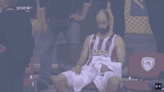 a basketball player with the number 7 on his jersey sits in a chair