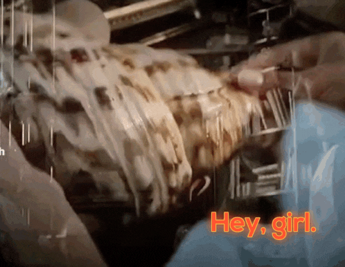 a close up of a person holding a piece of food with the words " hey girl " written on it