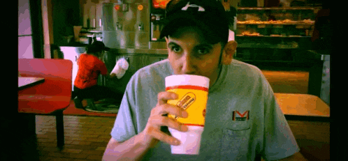 a man drinking from a cup that says hamburger helper on it