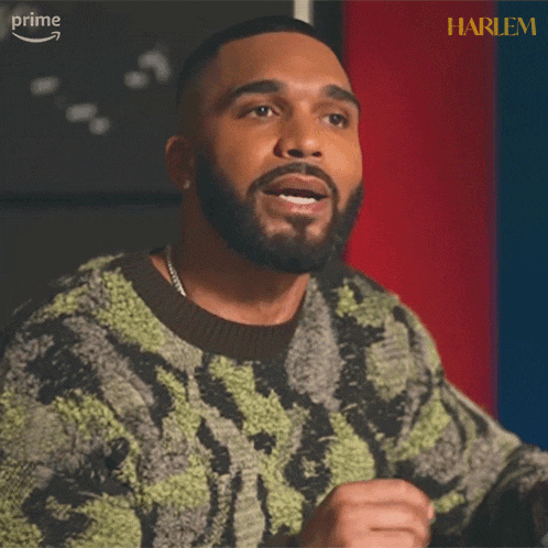 a man with a beard is wearing a sweater that says harlem on the bottom