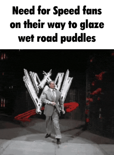 a man in a suit and tie is on a stage in front of a wwe logo