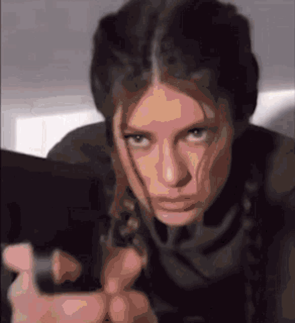 a close up of a woman holding a gun .