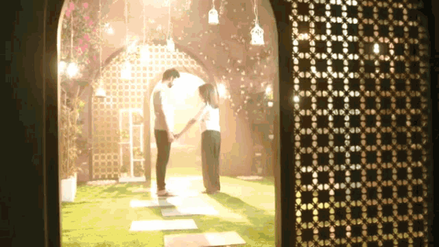 a man and a woman are holding hands in a room