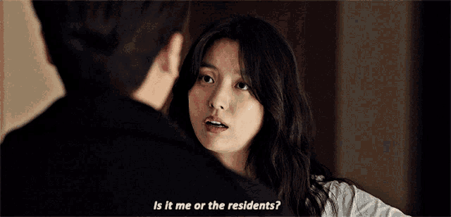 a man and a woman are looking at each other and the woman is asking if it is me or the residents