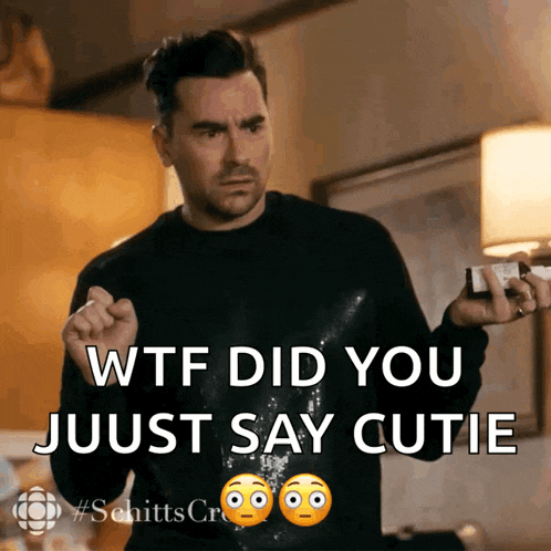 a man in a black sweater is holding a bottle and says wtf did you just say cutie