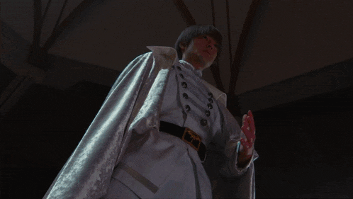 a man in a white robe is standing in a dark room