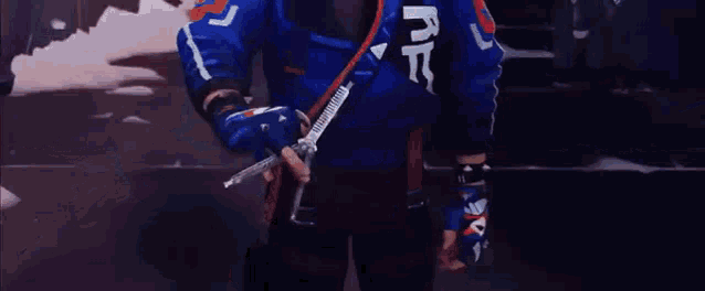 a man in a blue jacket and gloves is standing in a dark room .