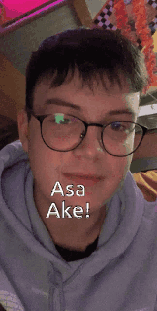 a man wearing glasses and a purple hoodie says asa ake