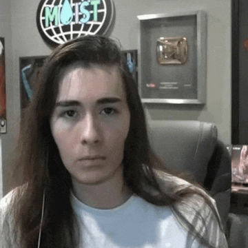 a woman with long hair is sitting in front of a sign that says most