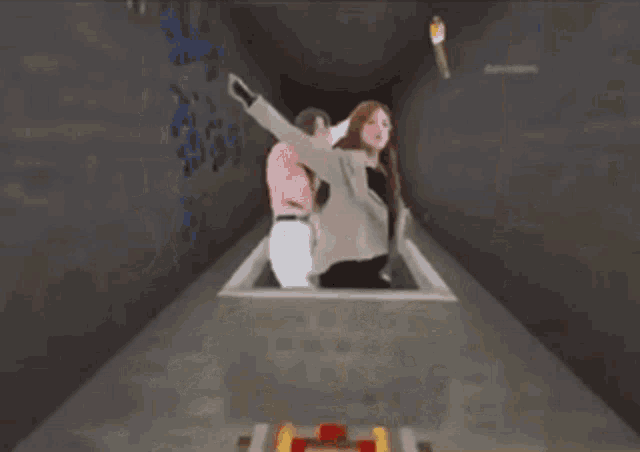 two women are riding a roller coaster with a torch in the background