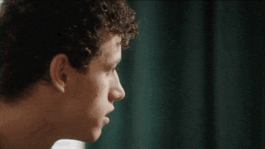 a close up of a man 's face looking out a window .