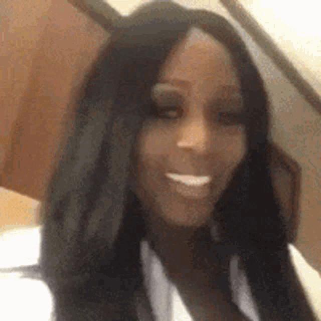 a close up of a woman 's face with long black hair smiling .