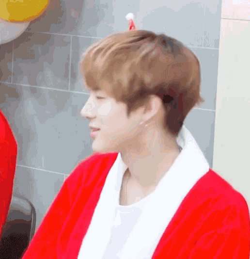 a young man is wearing a red santa suit and a white shirt