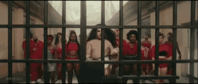 a group of women are behind bars in a jail cell