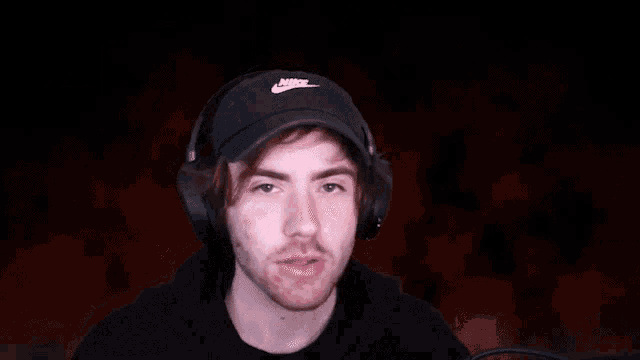 a man wearing headphones is blowing a kiss to the camera