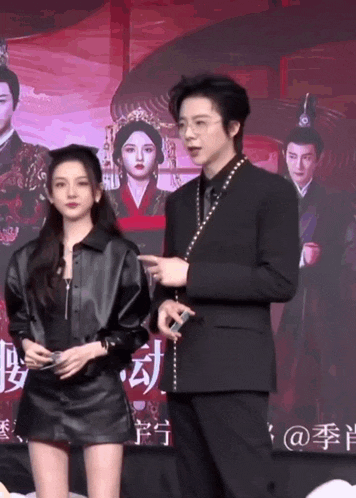 a man and a woman are standing next to each other in front of a poster for a movie