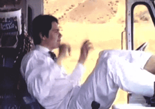 a man in a white shirt and tie is sitting in a car with his legs crossed