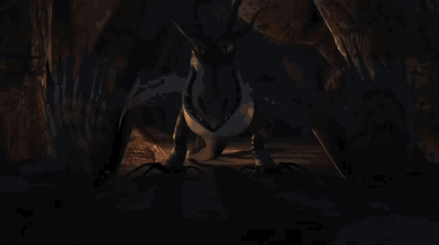 a dragon is surrounded by flames in a cave and is flying through the air .