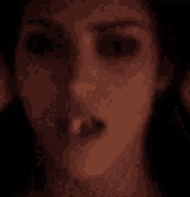 a close up of a woman 's face with her mouth open in the dark .