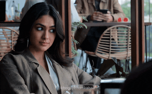 a woman sitting at a table with the hashtag khogayehum kahaa