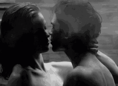 a man and a woman are kissing in a bathtub