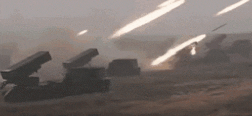a group of missiles are being fired from a military vehicle in a field .