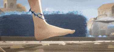 a woman 's foot with spikes on it is walking on a wooden surface