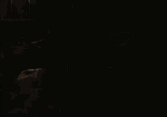 a baby yoda is sitting in a dark room .