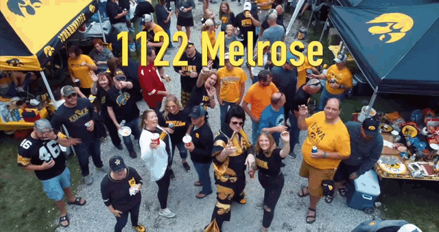 a group of people standing in front of a tent with the words 1122 melrose on it